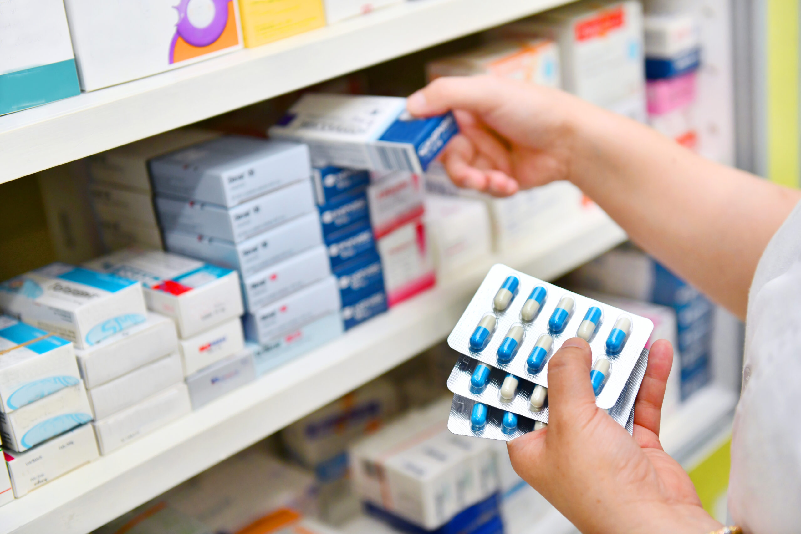 Pharmacist Holding Medicine Box And Capsule Pack In Pharmacy Dru